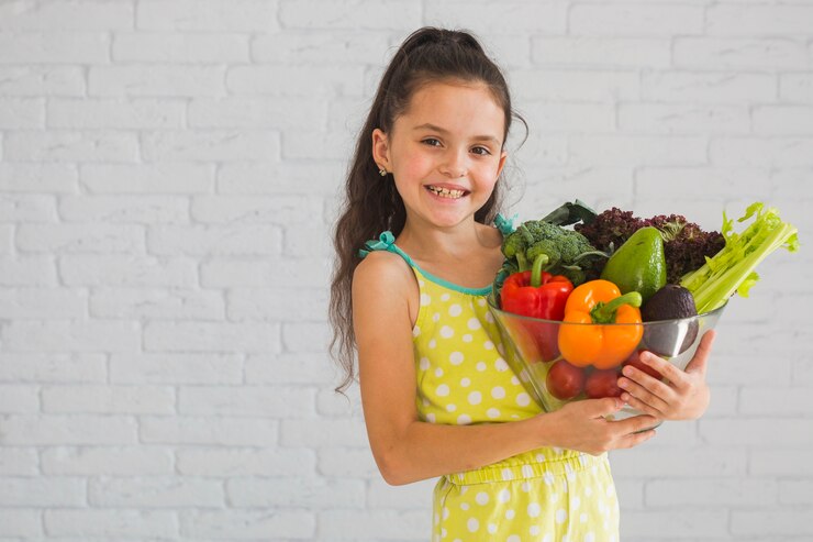 Criança segurando legumes