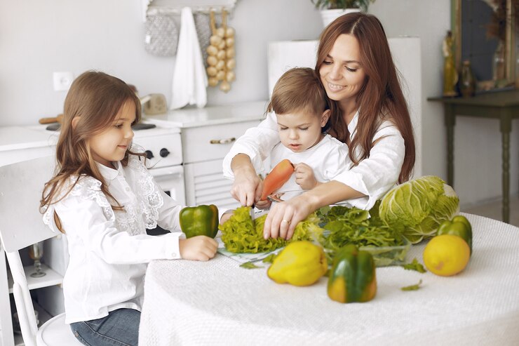 Mãe e filhos preparando refeições vegetarianas